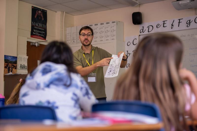  professor a explicar tarefa na aula do curso de inglês para jovens