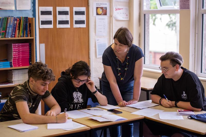 Professora a corrigir os trabalhos de casa juntamente com os alunos no curso de línguas juvigo