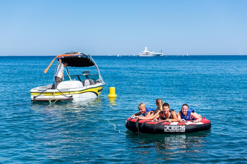 participantes numa bóia a ser puxada por um barco da atividade aquática do curso de linguas em frança