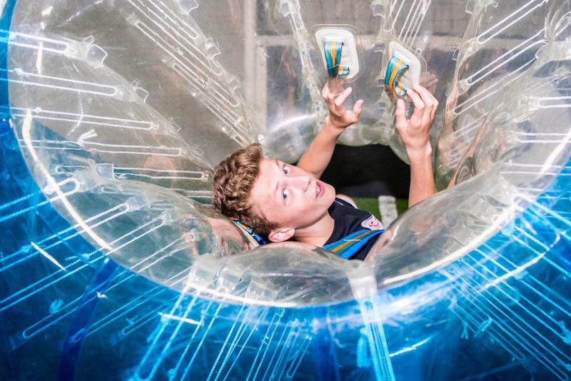Jovem participa numa atividade de bubble soccer durante um curso de línguas em França.