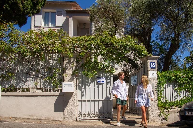 Participantess a caminhar em direção a um edifício rodeado de plantas num dia ensolarado, a caminho de um curso de língua francesa