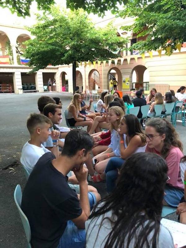 Grupo de jovens a conversar ao ar livre, aproveitando o tempo livre durante um curso de língua francesa