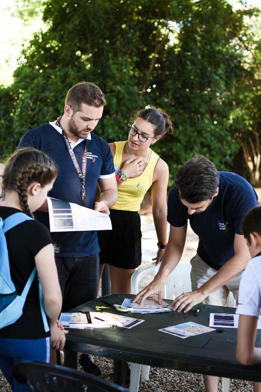 Equipa de instrutores a orientar um grupo de jovens durante as atividades ao ar livre no curso de lingua francesa