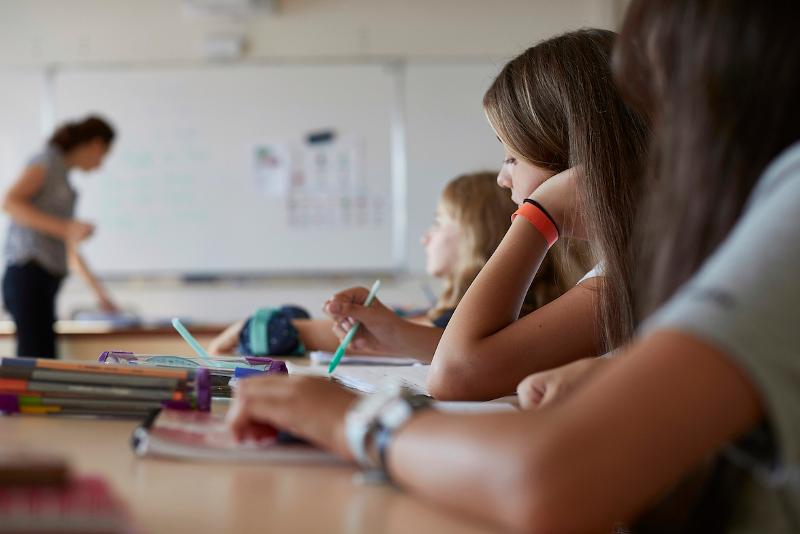 professora a ensinar e alunos a prestar atenção durante uma aula no curso de línguas