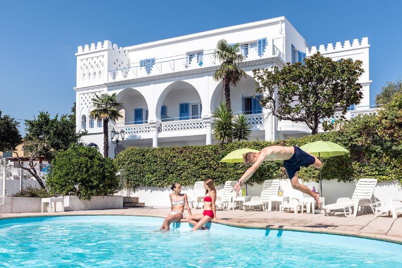 Tres participantes na piscina durante uma tarde de sol durante o curso de línguas no estrangeiro
