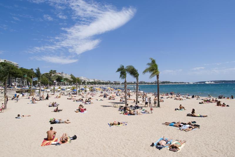 Praia de antibes com pessoas deitadas na toalha durante o curso de línguas no estrangeiro