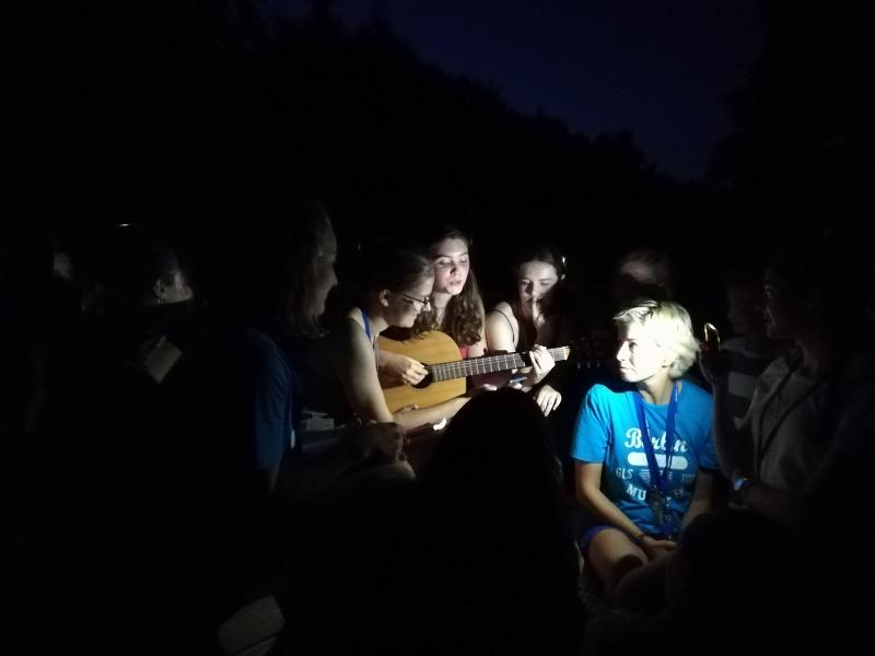 Grupo de estudantes a tocar viola durante uma atividade noturna, desfrutando de momentos de lazer enquanto fazem o seu curso de inglês na alemanha.