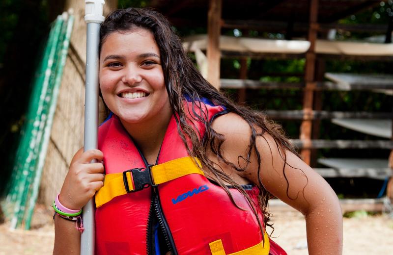 Rapariga a sorrir com um colete salva-vidas, pronta para uma aventura enquanto faz o seu curso de inglês na alemanha.