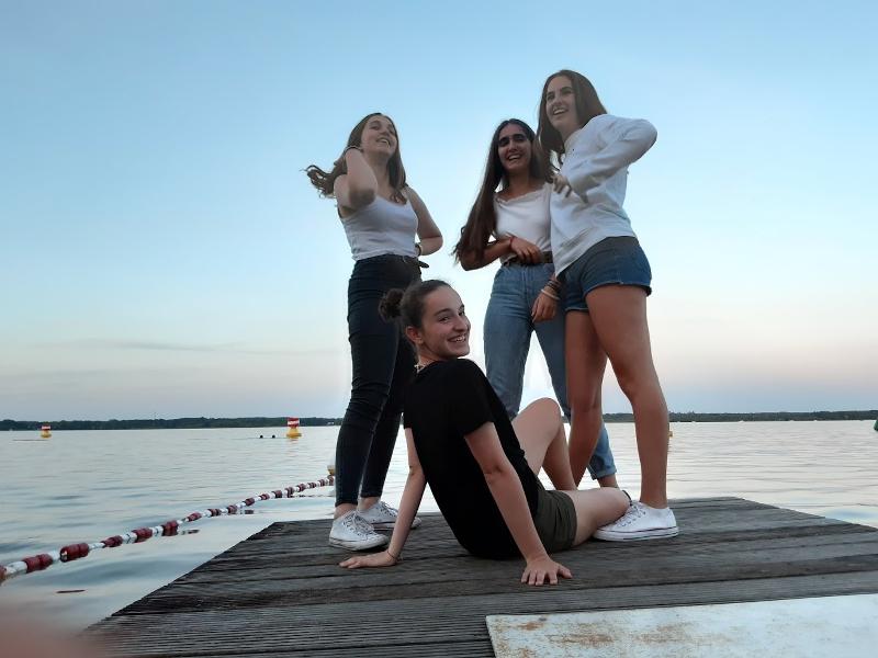  Quatro raparigas a contemplar o pôr do sol, a aproveitar a tranquilidade durante o seu curso de inglês na alemanha.