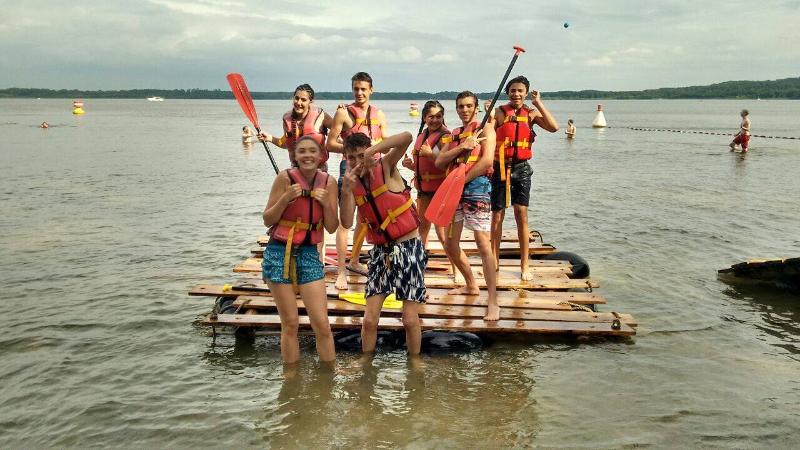 Grupo de participantes a posar para a foto após uma sessão de windsurf, celebrando a experiência do seu curso de inglês na alemanha.