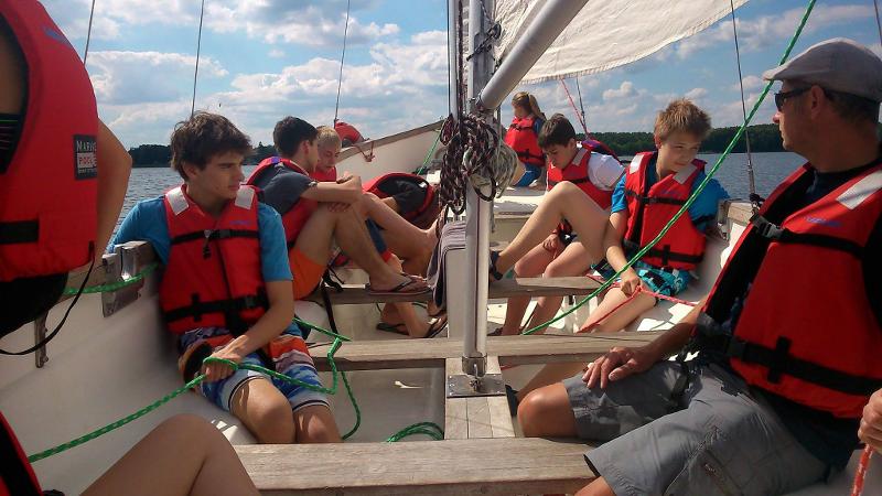 Grupo de estudantes no barco, a caminho de uma sessão de windsurf, aproveitando a aventura durante o seu curso de inglês na alemanha.