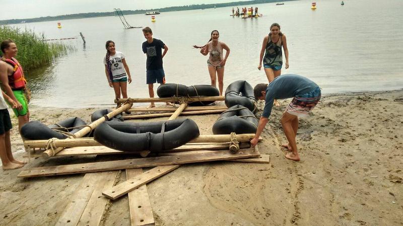 Participantes a construir um barco, trabalhando em equipa enquanto desfrutam da experiência do seu curso de inglês na alemanha.