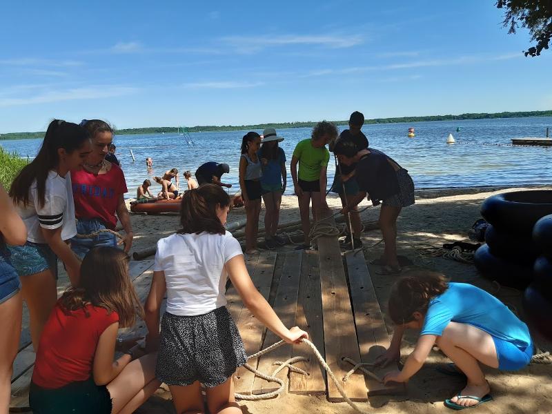  Participantes a construir a base de um barco num dia de sol, trabalhando em equipa durante o seu curso de inglês na alemanha.