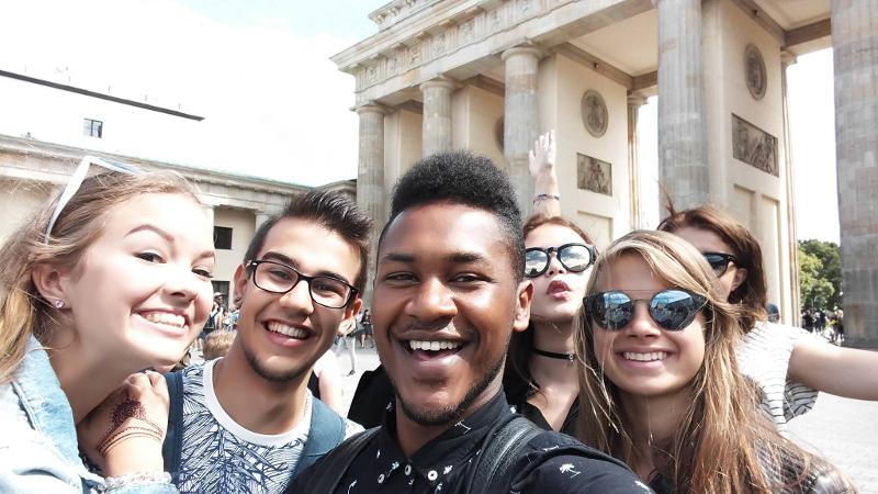Participantes a tirar uma selfie à frente da Porta de Brandeburgo, celebrando a experiência cultural durante o seu curso de inglês na alemanha.