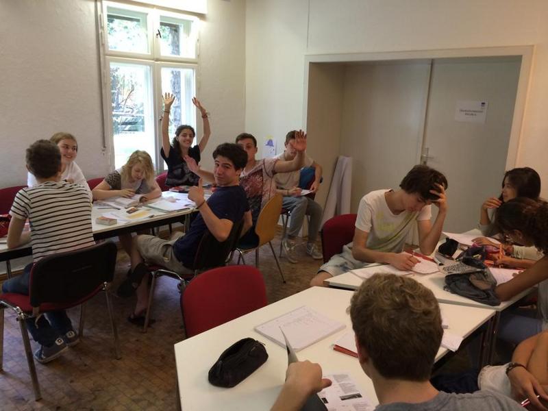 Grupo de estudantes na sala de aula, concentrados na aprendizagem durante o seu curso de inglês na alemanha.