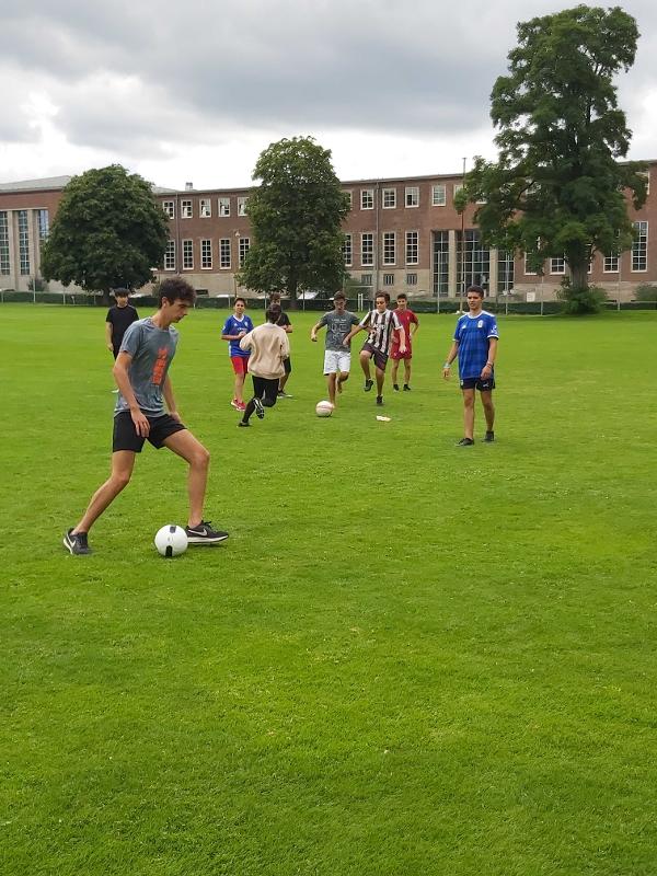 Rapazes participantes a jogar futebol, a divertir-se e a socializar durante o seu curso de inglês na alemanha.