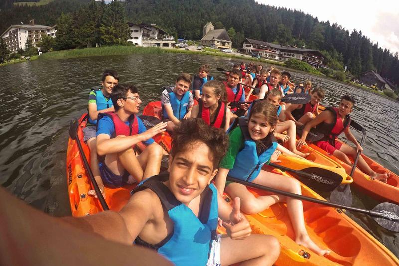 Grupo de participantes a fazer kayak, aproveitando a aventura ao ar livre durante o seu curso de inglês na alemanha.