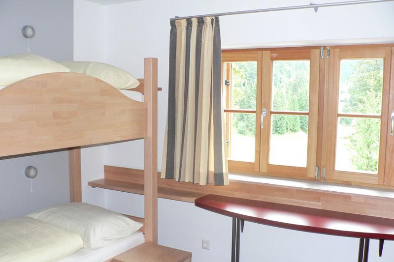 Quarto simples com beliche para duas pessoas e janela, oferecendo conforto e praticidade durante o teu curso de inglês na alemanha.
