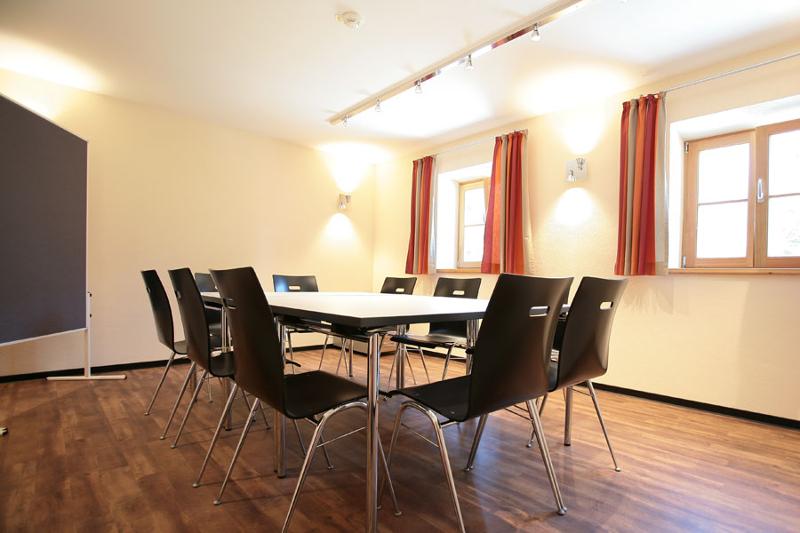 Interior de uma sala de aula, com mesas e cadeiras organizadas para os participantes do curso de inglês na alemanha.