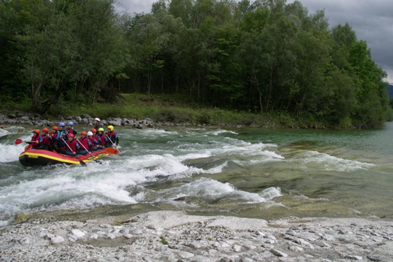 Grupo de participantes a fazer rafting, desfrutando da adrenalina e da natureza durante o seu curso de inglês na alemanha.