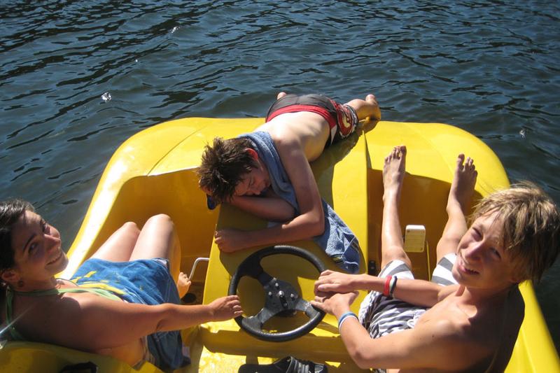 Três participantes num barco a pedal, explorando a natureza e desfrutando de uma experiência única durante o seu curso de inglês na alemanha.
