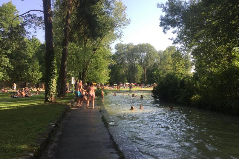 Rio em Munique com pessoas a nadar, aproveitando o clima e a natureza durante o seu curso de inglês na alemanha.
