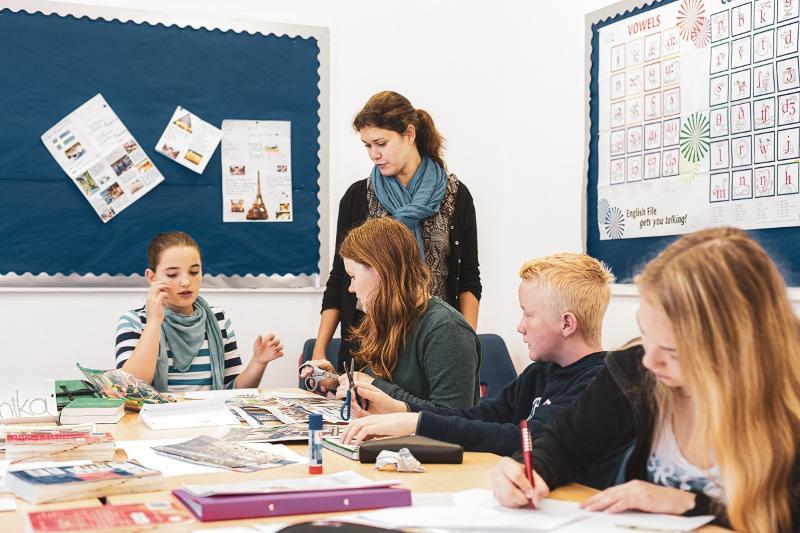  jovens com a professora num curso de inglês para jovens