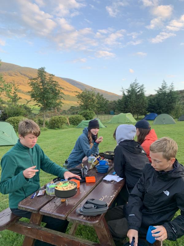 Jovens a almoçar no meio das montanhas, desfrutando da natureza enquanto fazem o seu curso de ingles na irlanda.