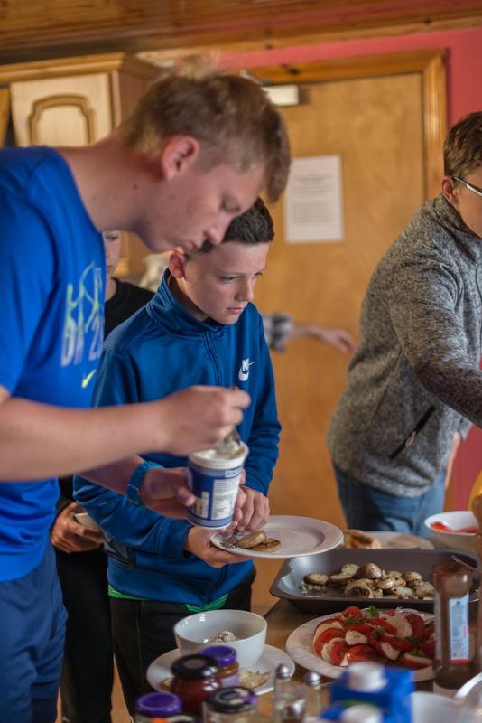 Jovens a cozinhar ao ar livre, aproveitando a experiência de cozinhar juntos enquanto fazem o seu curso de ingles na irlanda.
