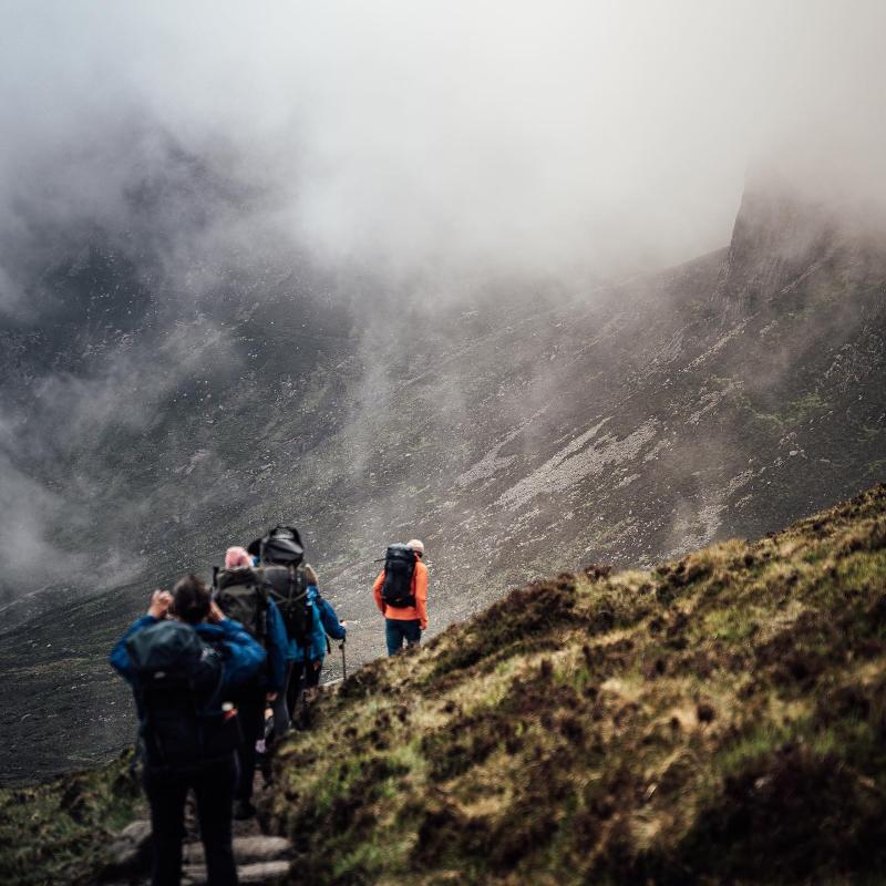 Jovens a fazer hiking nas montanhas, explorando a natureza enquanto fazem o seu curso de ingles na irlanda.