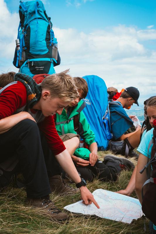 Jovens a consultar um mapa nas montanhas, a planear a próxima etapa da aventura enquanto fazem o seu curso de ingles na irlanda.