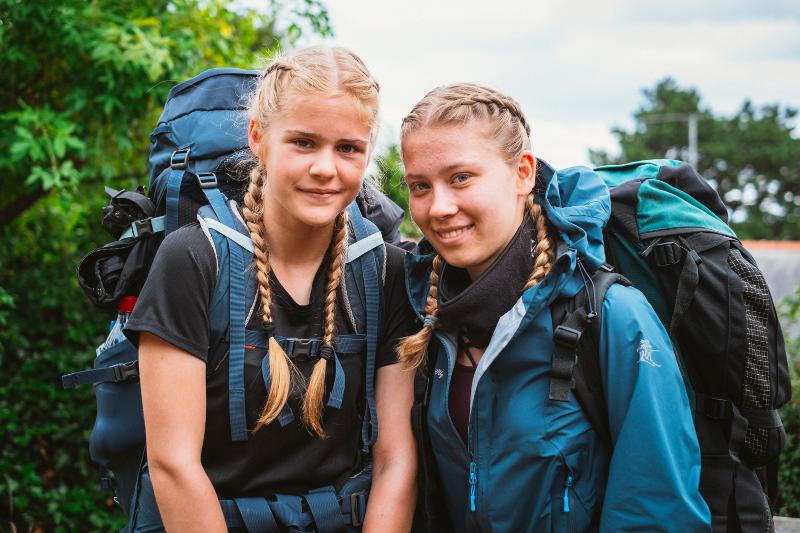 Duas meninas com mochilas grandes a sorrir, prontas para a aventura enquanto fazem o seu curso de ingles na irlanda.
