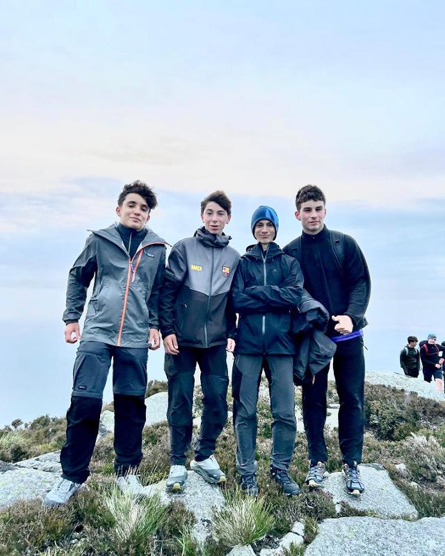 Grupo de 4 rapazes no topo da montanha, a celebrar a conquista enquanto fazem o seu curso de ingles na irlanda.