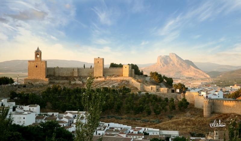 Vista panorâmica de uma fortaleza histórica com montanhas ao fundo, destacando o encanto da paisagem para um curso de lingua espanhola.