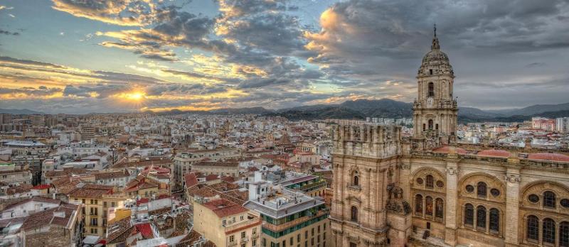 Panorama de cidade histórica com catedral imponente ao pôr do sol, um cenário deslumbrante para um curso de lingua espanhola.