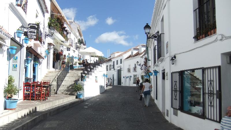 Rua pitoresca com casas brancas e vasos coloridos, perfeita para explorar cultura local durante um curso de lingua espanhola.