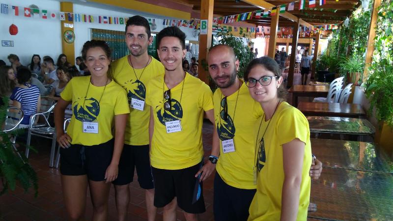 Grupo de jovens monitores com blusas amarelas e crachás, prontos para liderar atividades durante um curso de lingua espanhola.