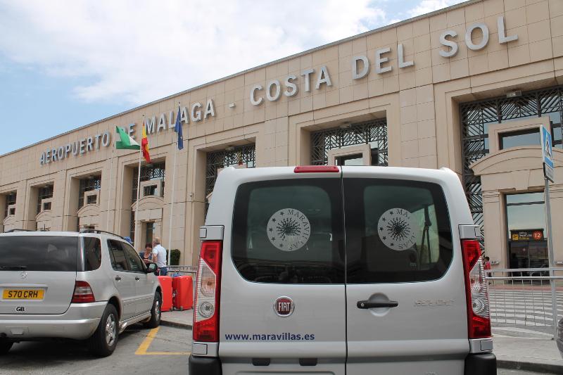 Fachada do Aeroporto de Málaga com uma carrinha de transporte, ideal para receber alunos de um curso de espanhol.