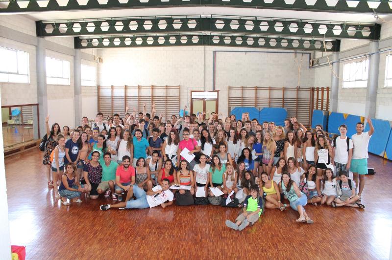 Grande grupo de estudantes a posar em sala ampla, celebrando o fim de atividades num curso de espanhol.