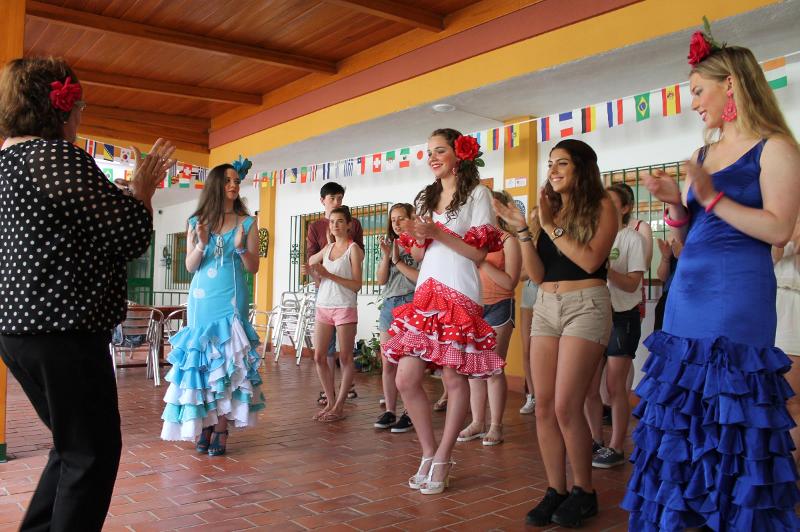 Grupo de estudantes a aprender a dançar flamenco com trajes tradicionais, numa atividade cultural de um curso de espanhol.