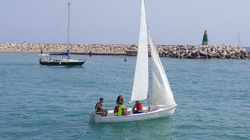 Grupo de estudantes a navegar num barco a vela, aproveitando o mar durante o seu curso de espanhol.
