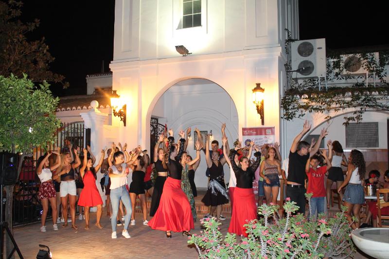 Estudantes a dançar ao ar livre durante a noite, enquanto participam no curso de espanhol e nas atividades culturais.