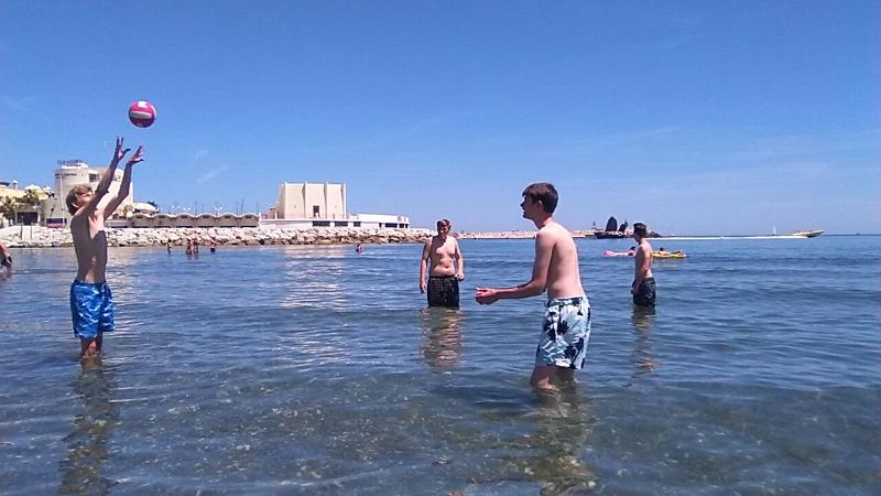Grupo de jovens a jogar à bola na água, aproveitando o calor enquanto desfrutam dos cursos de linguas em espanha.