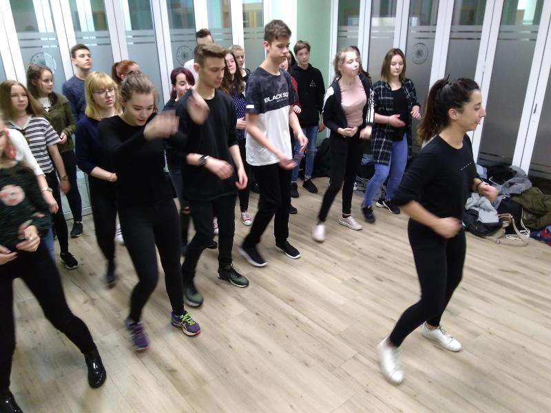 Estudantes participando numa aula de dança, movendo-se em grupo durante os cursos de linguas em espanha.