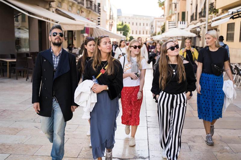 Seis jovens a andar nas ruas de Málaga a apreciar a beleza das ruas durante um curso de linguas no estrangeiro