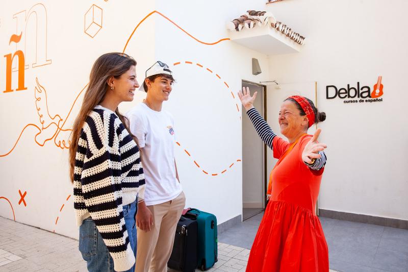 Professora da Debla a receber dois alunos de forma calorosa durante o curso de línguas de verão em espanha