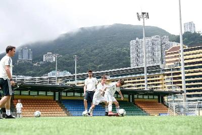 dois participantes a jogarem à bola no campo de férias