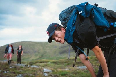 Jovem a fazer hiking na montanha, explorando a natureza e superando desafios enquanto faz o seu curso de ingles na irlanda.